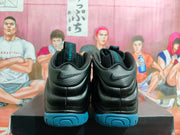 Rear view of black Nike Foamposite sneakers showing blue outsoles, padded collars and heel branding.