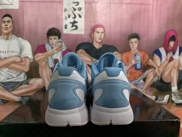 Rear view of blue Nike Kobe basketball shoes with white midsoles and signature heel detailing