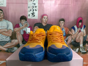Front view of yellow and blue basketball sneakers with orange laces