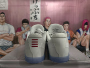 Rear view of white basketball shoes showing contrasting heel details and blue-toned outsoles.