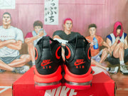 Rear view of black and red high-top sneakers showing Nike and Air heel branding, red midsoles, and clear heel sections.