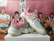 Side view of pink and aqua Adidas sneakers showing layered overlays, lace-up fastening, and sculpted soles.