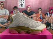 Side profile of an olive, cream, and pink sneaker with embossed patterned panels and a segmented outsole.