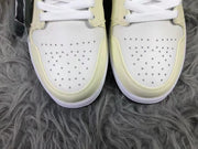 Close-up of the perforated white toe boxes framed by cream-colored overlays.