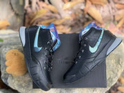 Pair of shoes displayed on a box, showing black uppers and blue accent details.