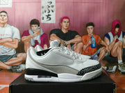 Side view of white and grey Jordan low-top sneakers with a patterned toe overlay and visible Air unit.