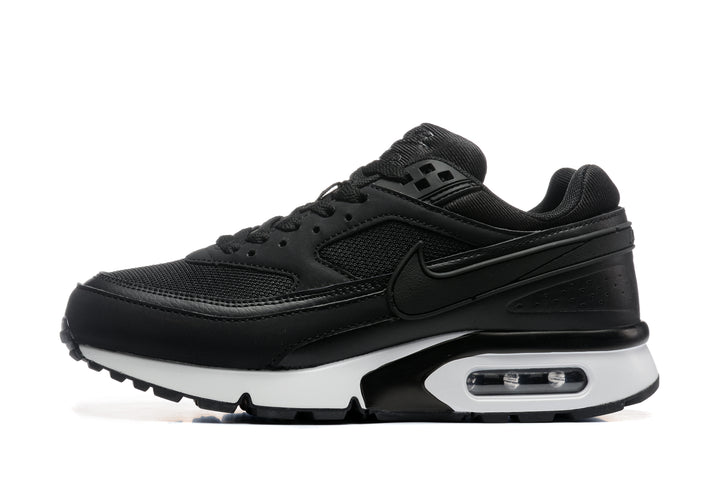 Side view of a black Nike Air Max BW-style sneaker with mesh panels, a white midsole, and visible heel air unit.