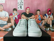 Front view showing the perforated uppers, laces, and white textured outsoles of the sneakers.