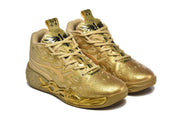 Angled front view of the matching gold sneakers with tonal laces and graphic overlays.