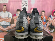 Rear view of gray and black Nike high-top basketball sneakers with gold side accents and translucent segmented soles.