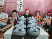 Front view showing matching grey and black basketball sneakers with black tongue logos.