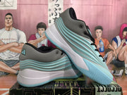 Angled view of blue-gray Adidas basketball sneakers showing the layered side design, heel structure, and textured outsole.
