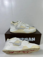 Side and outsole views of white and cream Jordan sneakers with a gray Swoosh, cream outsole, and red outsole graphic details.