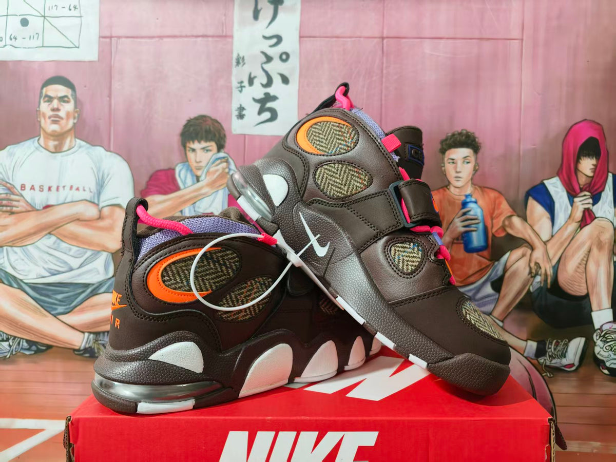 Pair of brown Nike high-top basketball sneakers with pink and orange accents displayed on a Nike shoe box.
