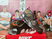 Pair of brown Nike high-top basketball sneakers with pink and orange accents displayed on a Nike shoe box.