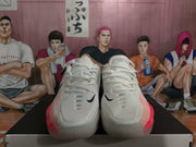 Front view of white lace-up Nike basketball shoes with black Swoosh details and pink accents.