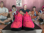 Front view of rose-red Nike basketball sneakers with perforated toe boxes, lace-up fronts and black toe areas.