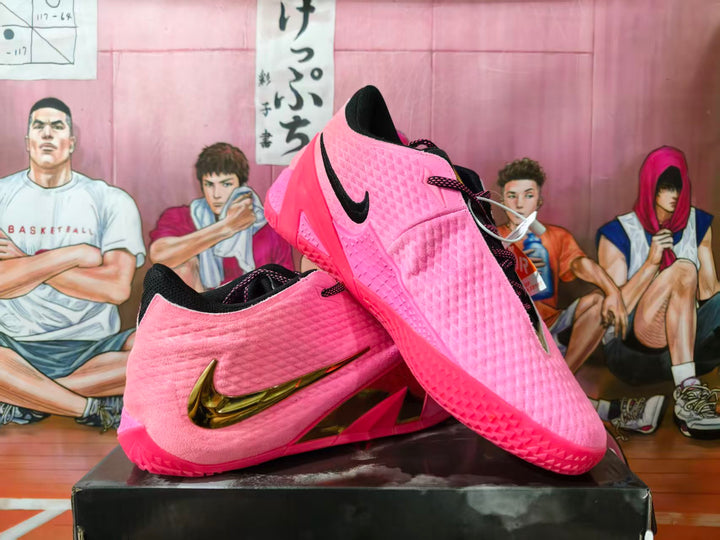 Pair of pink Nike basketball sneakers with black accents, gold Swoosh detailing, and sculpted soles.