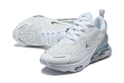 Angled view of white Nike Air Max 270 Premium sneakers with perforated-looking uppers and dark Swoosh accents.