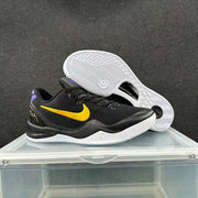 Black and gold Nike basketball sneaker displayed with the patterned white outsole visible.