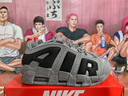 Side profile of a gray and black Nike sneaker showing mesh panels, gray overlays, red accents, and a visible air cushioning window.