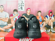 Rear view of black Nike sneakers with heel pull tabs and graphic heel details.