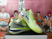 Angled view showing the green mesh side panels, dark swoosh detail, contrasting midsole, and outsole.