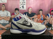 Side view of a white and purple Nike basketball shoe showing a black Swoosh and Kobe-inspired badge.