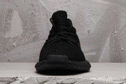 Front view of a black lace-up sneaker with a textured upper and rounded ribbed sole.