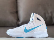 Outer side view showing the white high-top upper, blue Swoosh, perforated panels, and textured outsole.