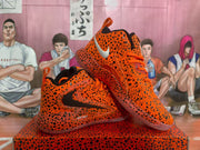 Angled view of the paired orange leopard-print sneakers showing the collars, laces, and side details.