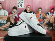 Angled side view of the paired sneakers, highlighting the white uppers, black collars, and red side emblems.
