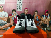 Front view of a pair of gray, black, and white lace-up wrestling-style shoes with padded tongues.