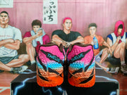 Rear view of black, pink, blue, and orange Nike basketball sneakers displayed on a box.