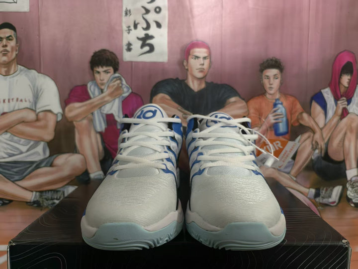 Front view of white and blue basketball shoes with black detailing and light blue outsoles