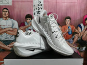 Pair of white Nike GT basketball sneakers shown from angled side and front views with black Swoosh details.