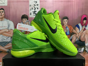 Angled view of two lime green Nike basketball sneakers displaying the black Swoosh, textured uppers, red tongue emblems, and contrasting green midsoles.