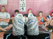 Rear view of white and gray basketball shoes with blue “TWELVE” heel lettering and patterned outsoles.