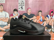 Side profile of a black low-top basketball shoe with textured overlays and a contrasting side logo