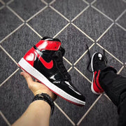 Angled side view of the black and red high-top sneaker with a red Swoosh-style detail.
