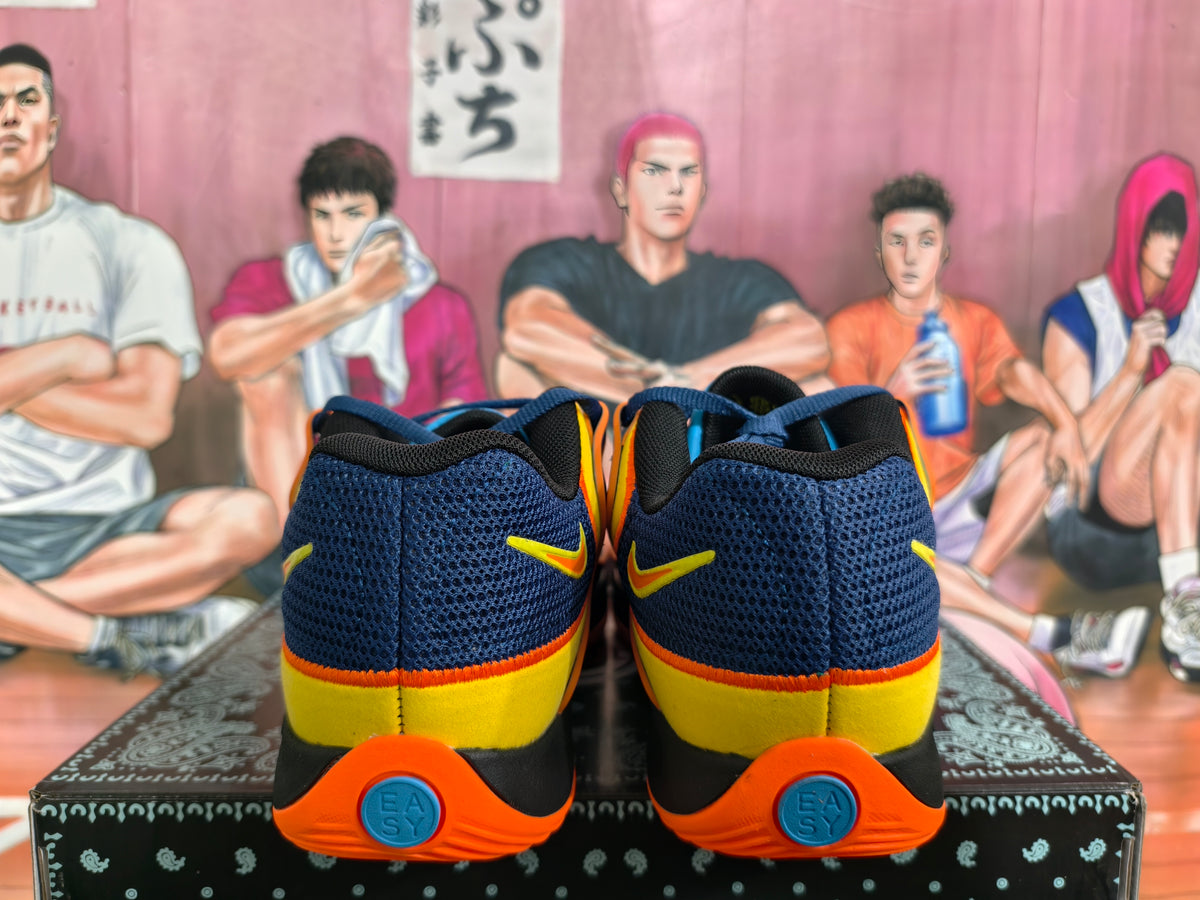 Rear view of navy Nike basketball sneakers with yellow heel panels and orange outsoles