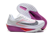 Side and outsole views of white Nike Zoom Fly 6 shoes with purple and coral accents.