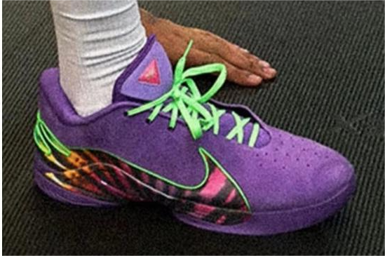 Purple Nike LeBron 22 shoe with bright green laces and a multicolor side and heel graphic.