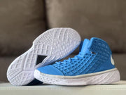 Blue sneaker pair with one outsole lifted to reveal the white traction pattern.