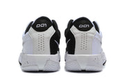 Rear view of the white and black Nike Academy sneakers showing perforated heel panels and patterned outsoles.