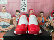 Front view of the pair of white and red high-top sneakers, showing the red toe overlays and textured white upper sections.