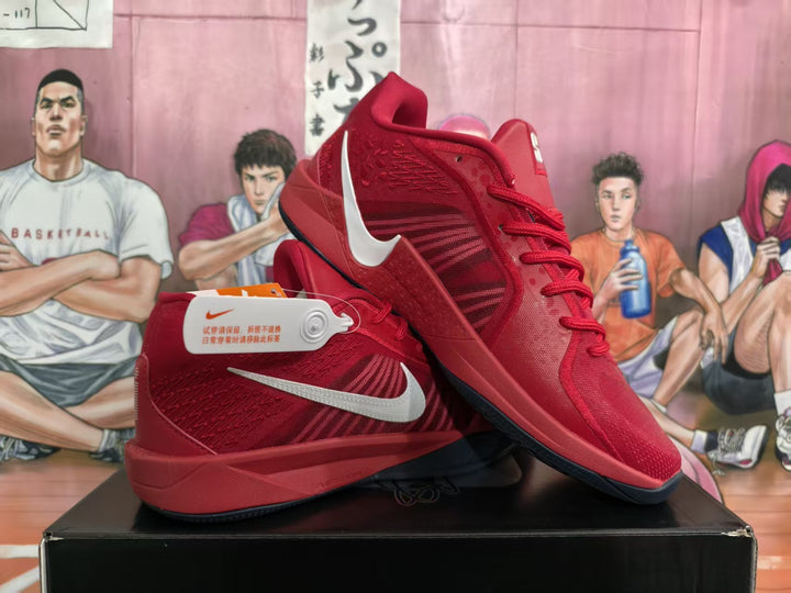 Pair of red Nike basketball sneakers shown from the side on a black box, with light-colored Swoosh logos and a basketball-themed background.