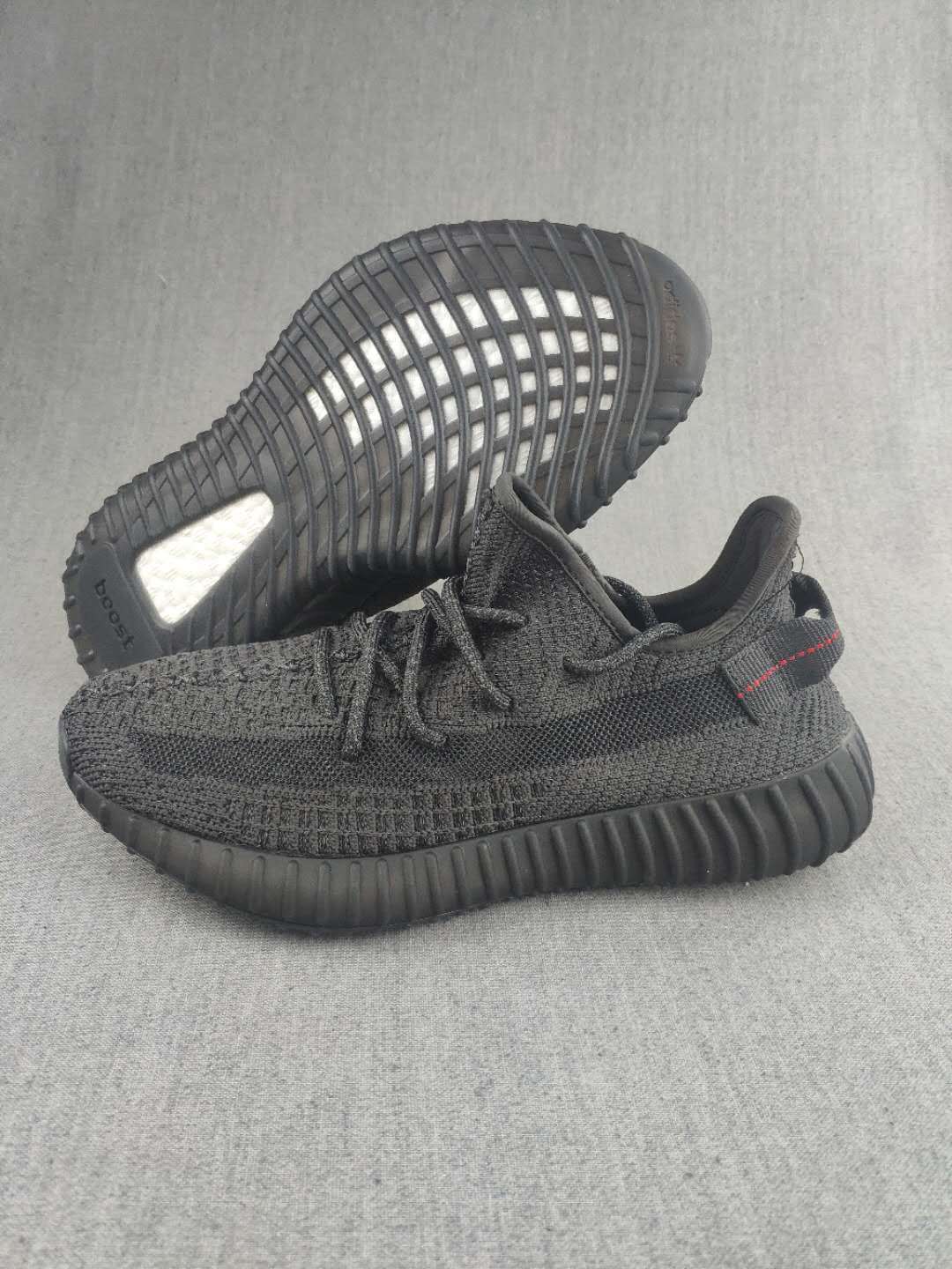 Pair of black knit low-top sneakers shown from the side and outsole.