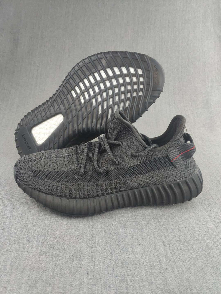 Pair of black knit low-top sneakers shown from the side and outsole.