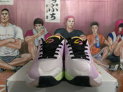 Front view of the sneaker pair showing black laces, lavender-pink uppers, light toe panels, and green sole accents.